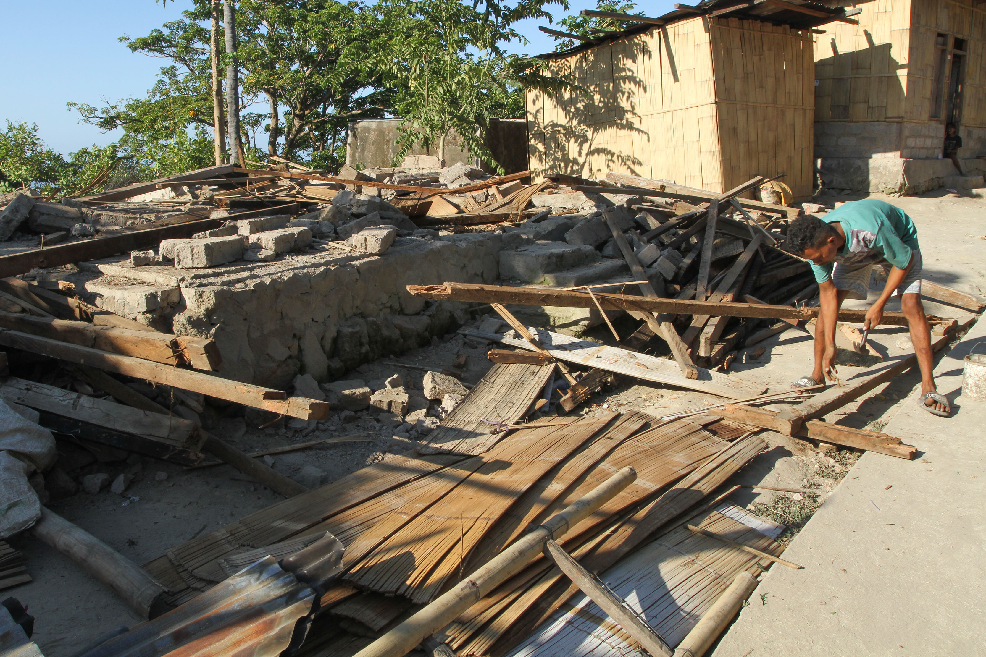 Seorang warga membersihkan rumah yang rusak usai gempa di Desa Lidi, NTT pada Jumat (4/9/2026)